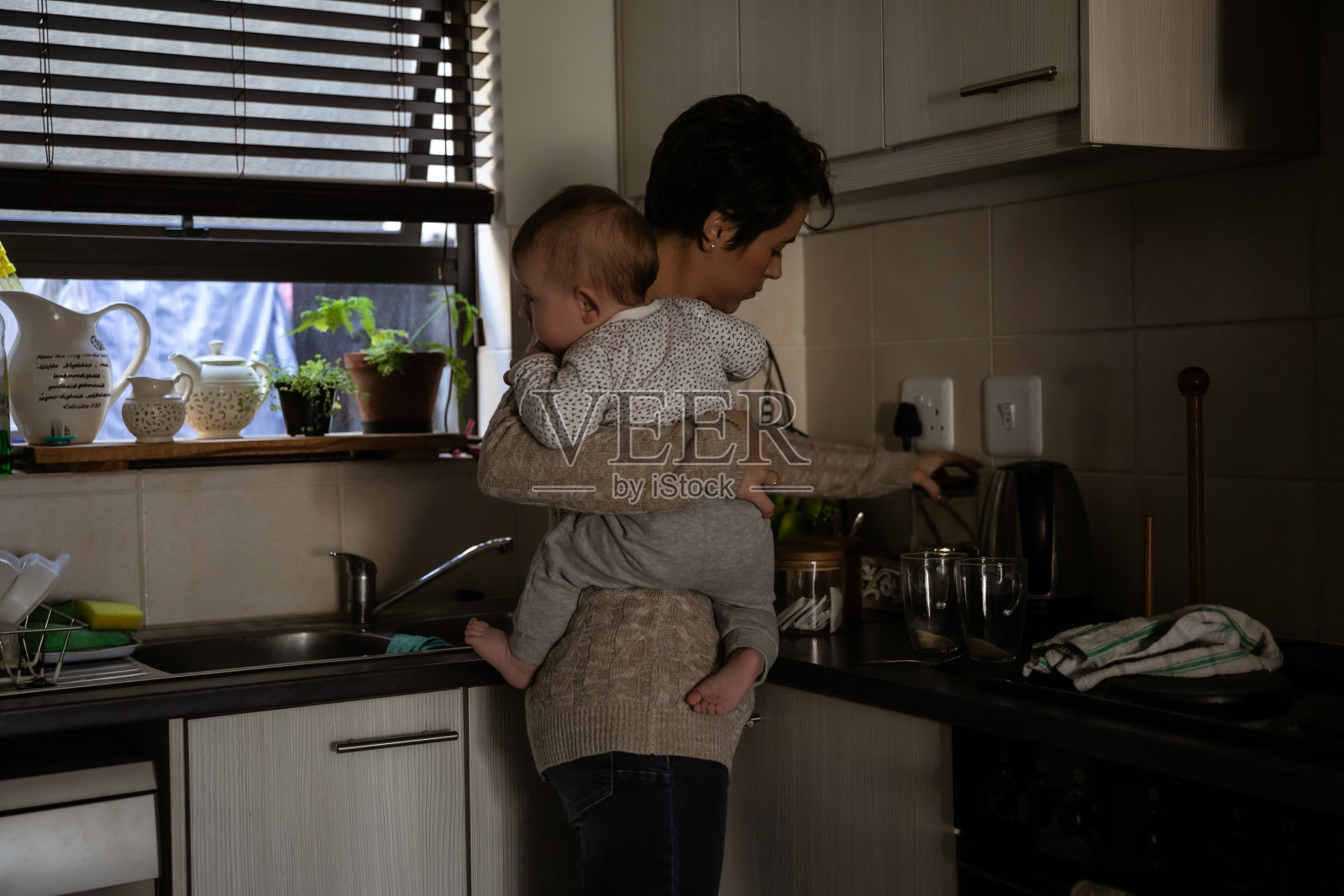 母亲带着两个孩子试图同时处理多项任务照片摄影图片