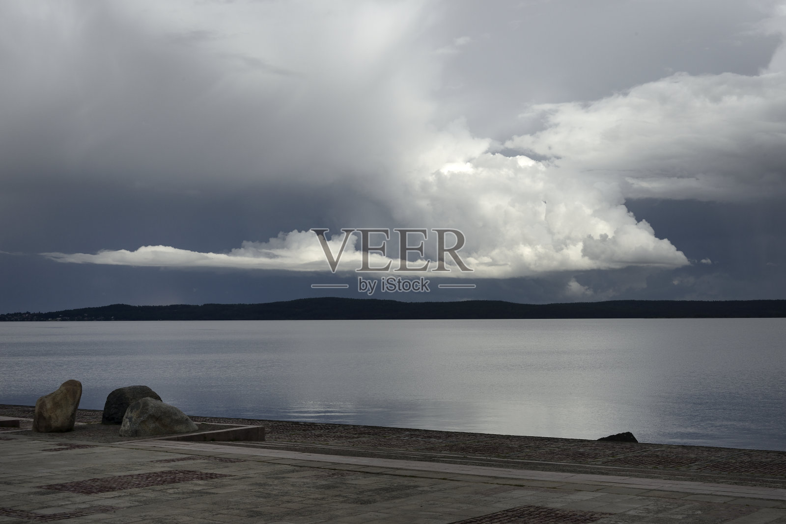 俄罗斯彼得罗扎沃茨克市奥涅加湖的河堤,表现了水面上的云照片摄影图片