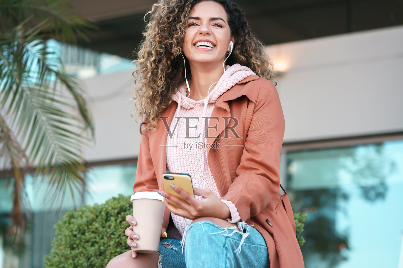 一个拉丁女人在街上用手机。照片摄影图片