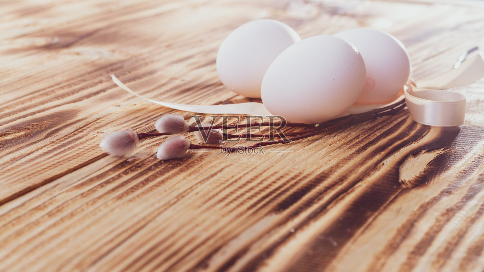 明亮的复活节贺卡在复古风格与白色鸡蛋和含苞待放的柳树米色木制背景照片摄影图片