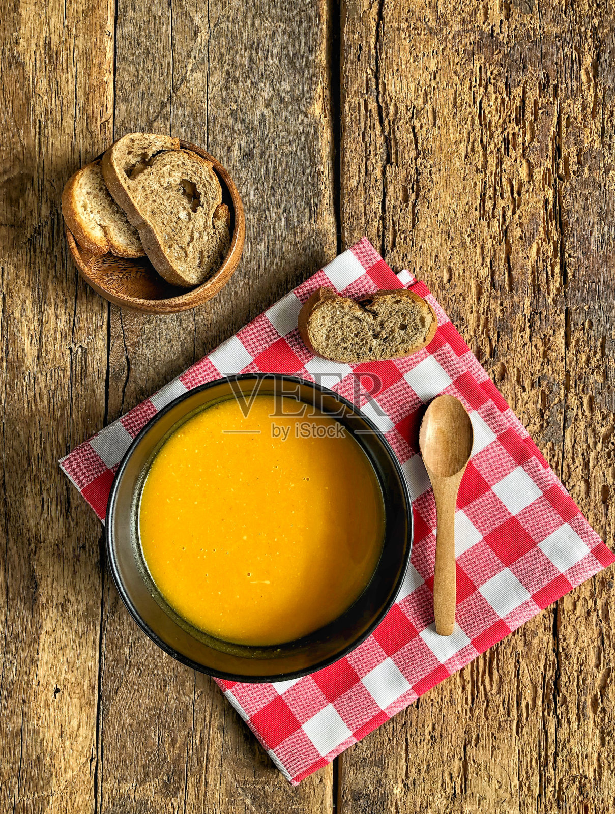 木桌上有一碗南瓜汤照片摄影图片