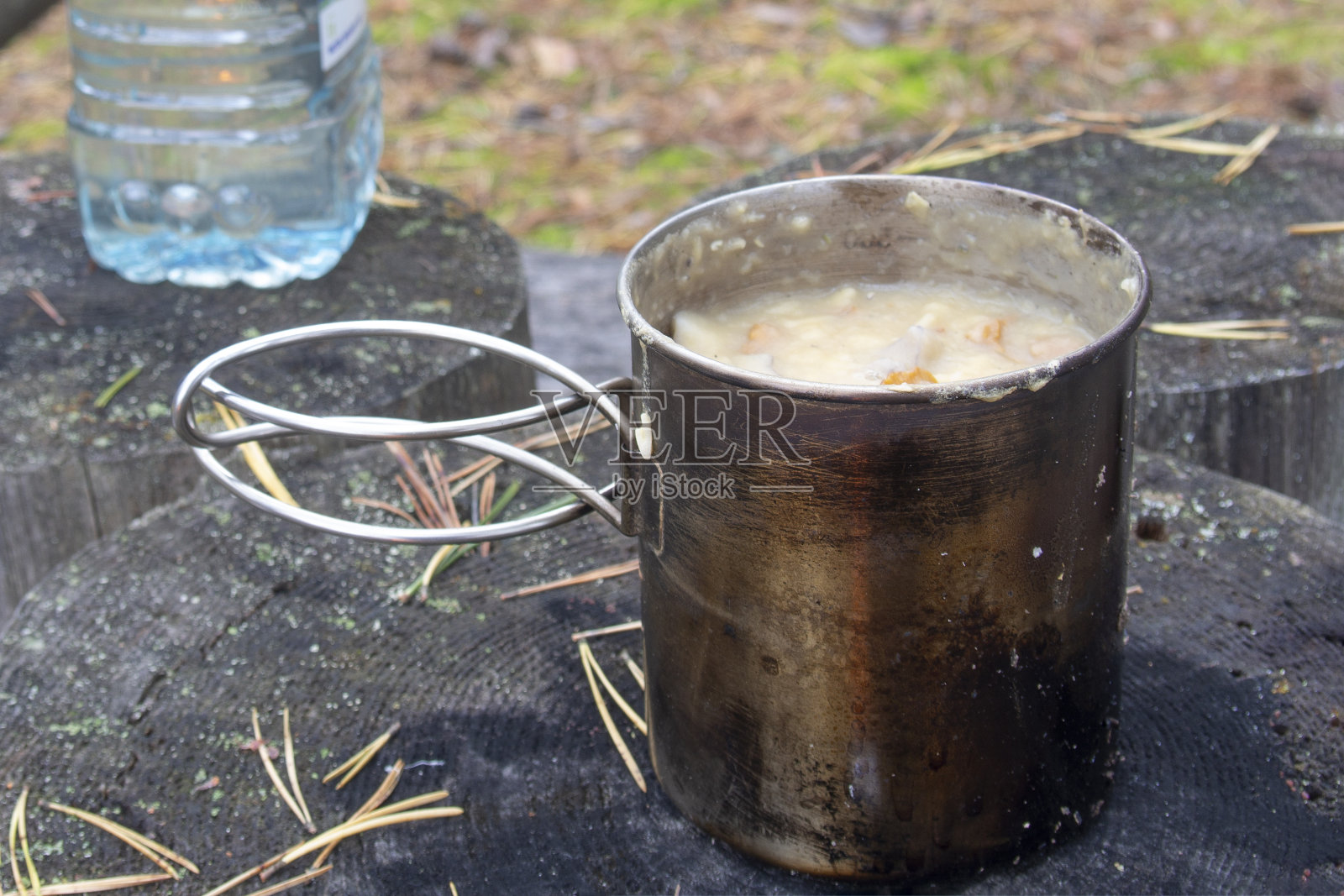 在篝火上用金属杯烹饪徒步旅行的食物照片摄影图片