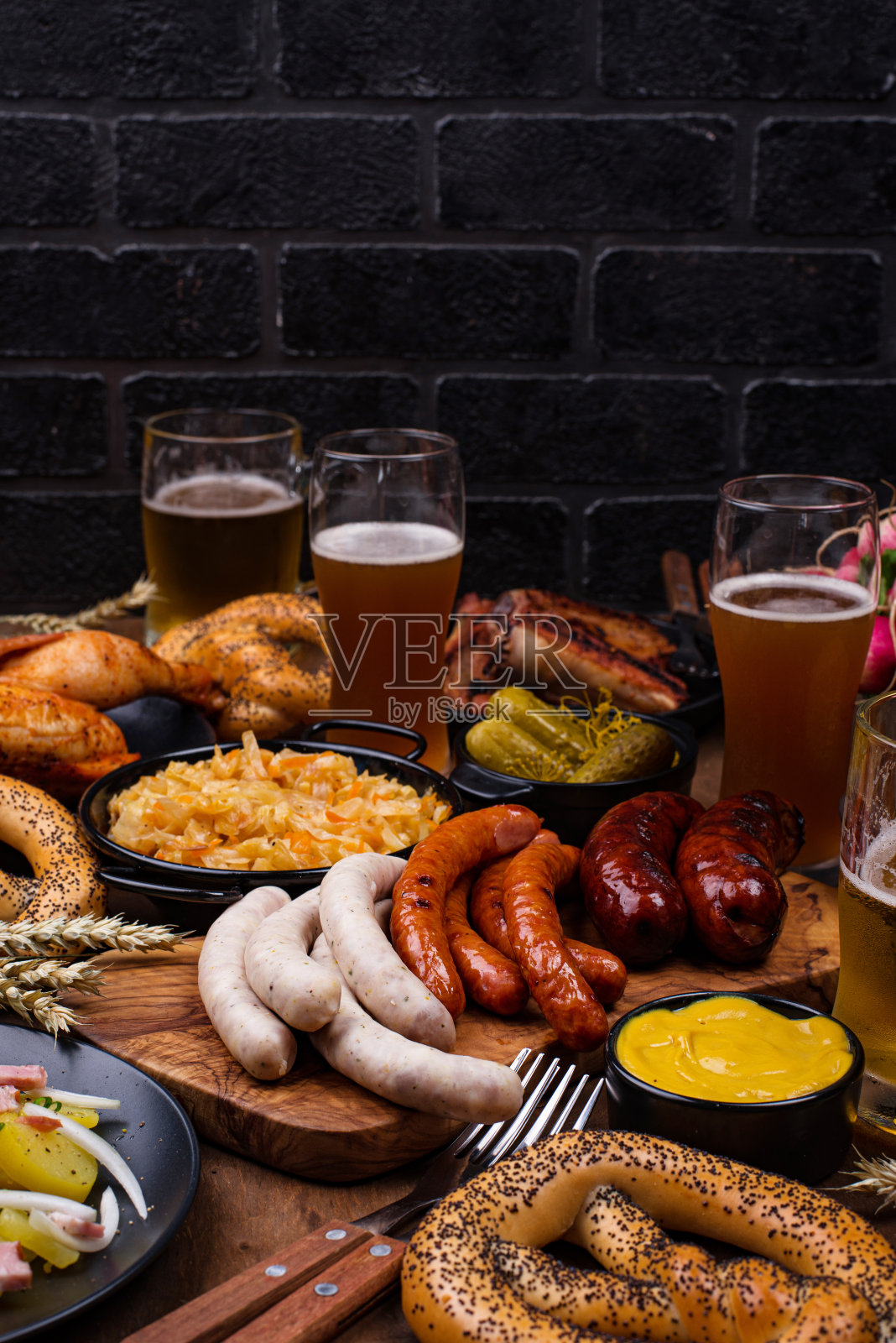 啤酒节的菜肴有啤酒、椒盐卷饼和香肠照片摄影图片