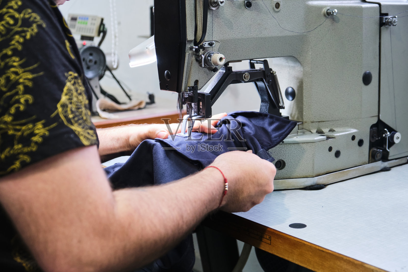 一个不认识的人使用缝纫机的手的裁剪视图照片摄影图片