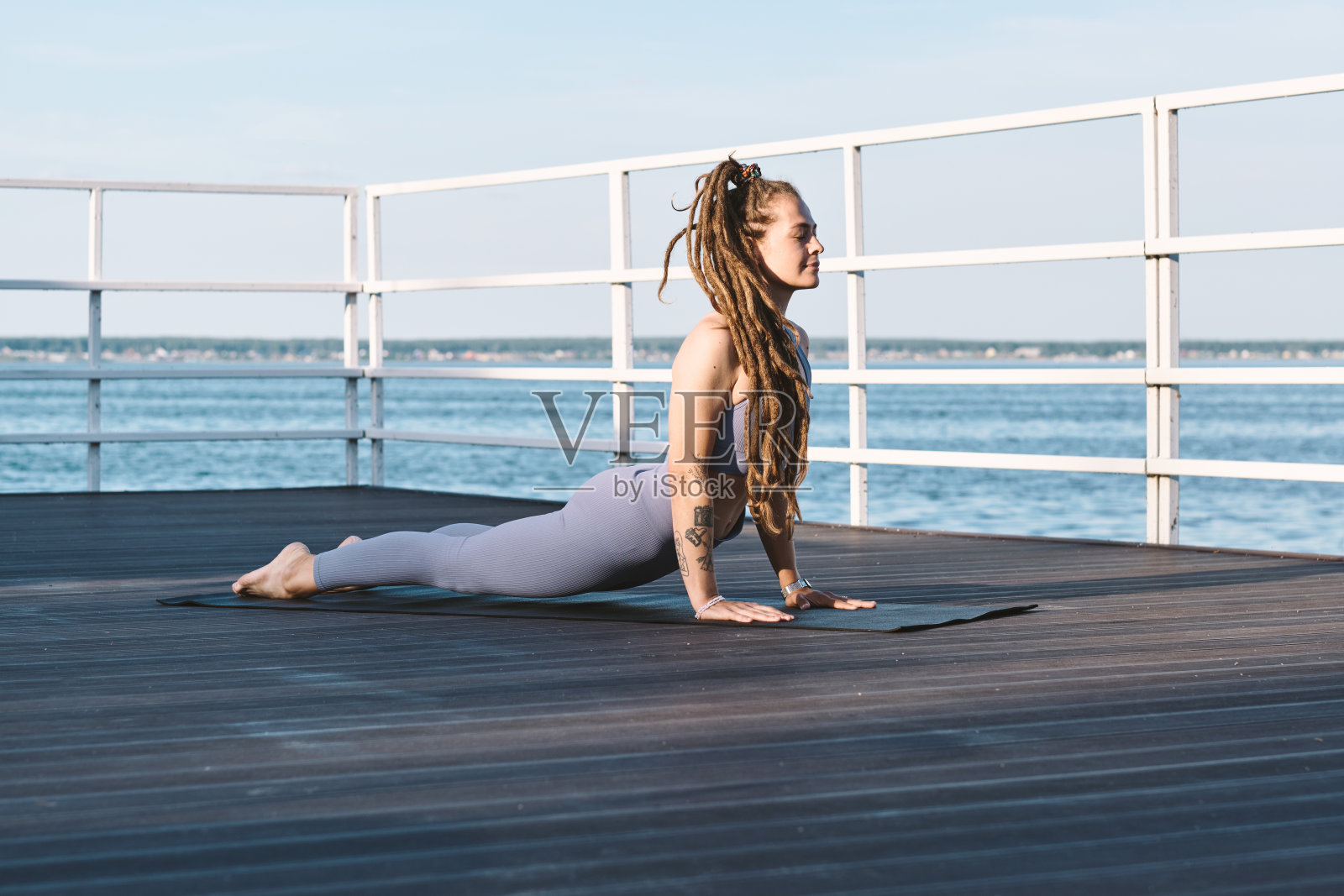 快乐的年轻女性在运动服练习瑜伽练习照片摄影图片