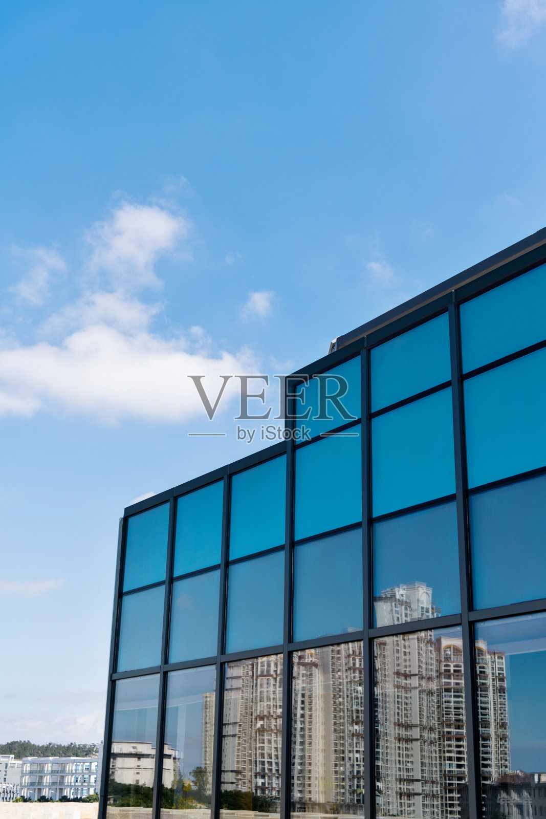 拥挤的公寓倒映在现代建筑的玻璃窗上照片摄影图片