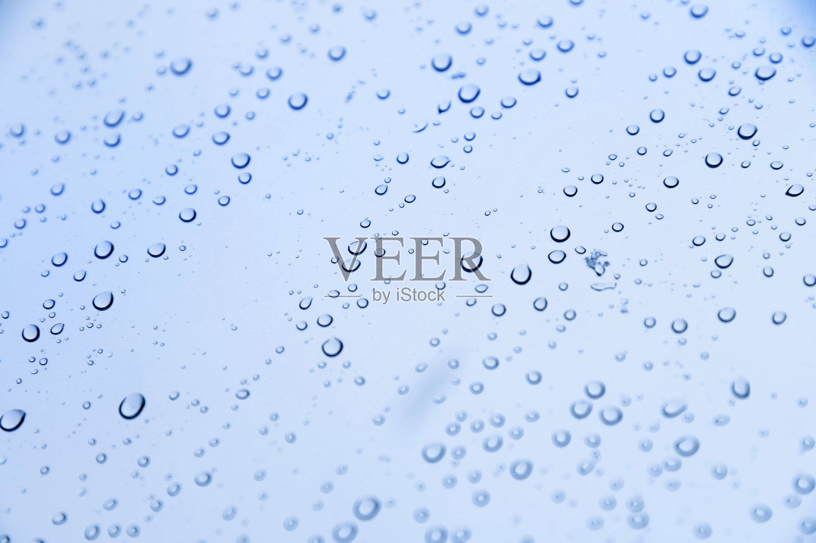 玻璃上冷色的雨滴。软焦点冷背景雨天照片摄影图片