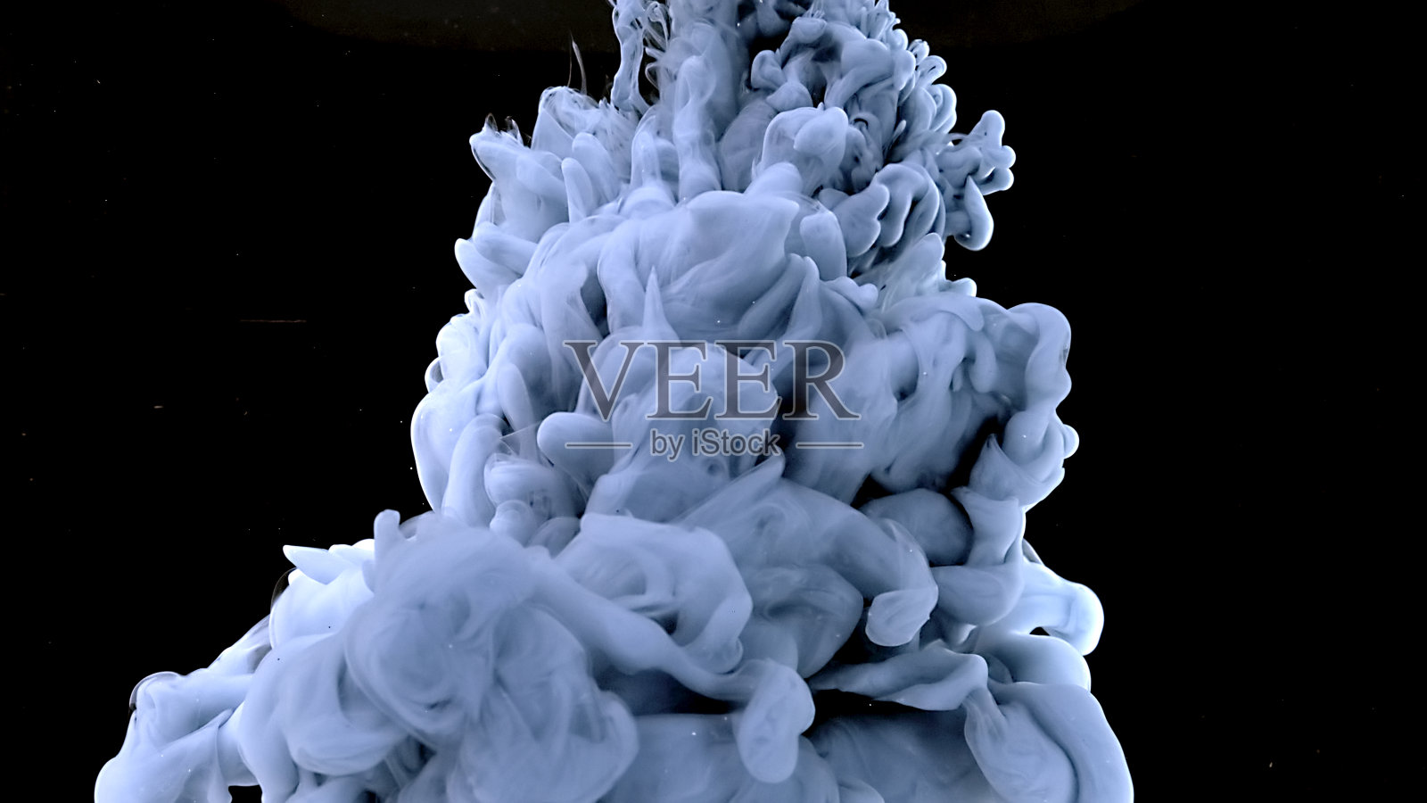 美丽的抽象背景。神奇的太空背景。浅蓝灰色水彩墨水在黑色背景上的水。蓝灰色墨水云。照片摄影图片