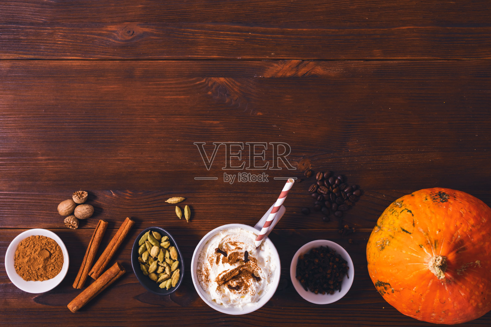 南瓜香料拿铁在马克杯与稻草旁边的有机调料肉桂照片摄影图片
