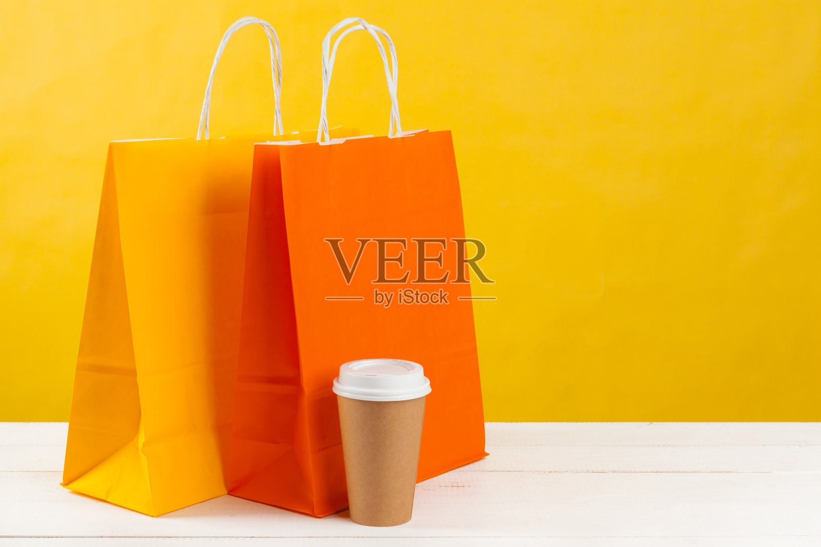 在亮黄色背景上摆放购物袋照片摄影图片