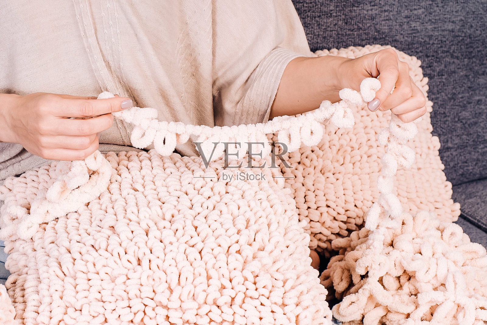 由厚而软的纱线制成的针织物。厚纱编织的软靠垫。照片摄影图片