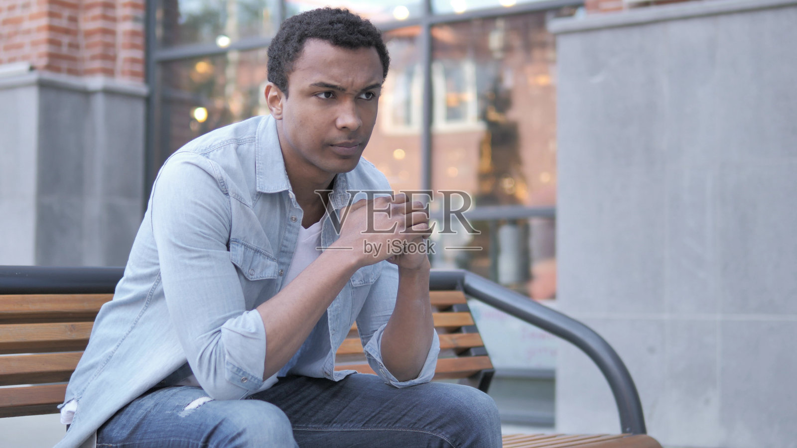 患有头痛的非洲人坐在户外照片摄影图片