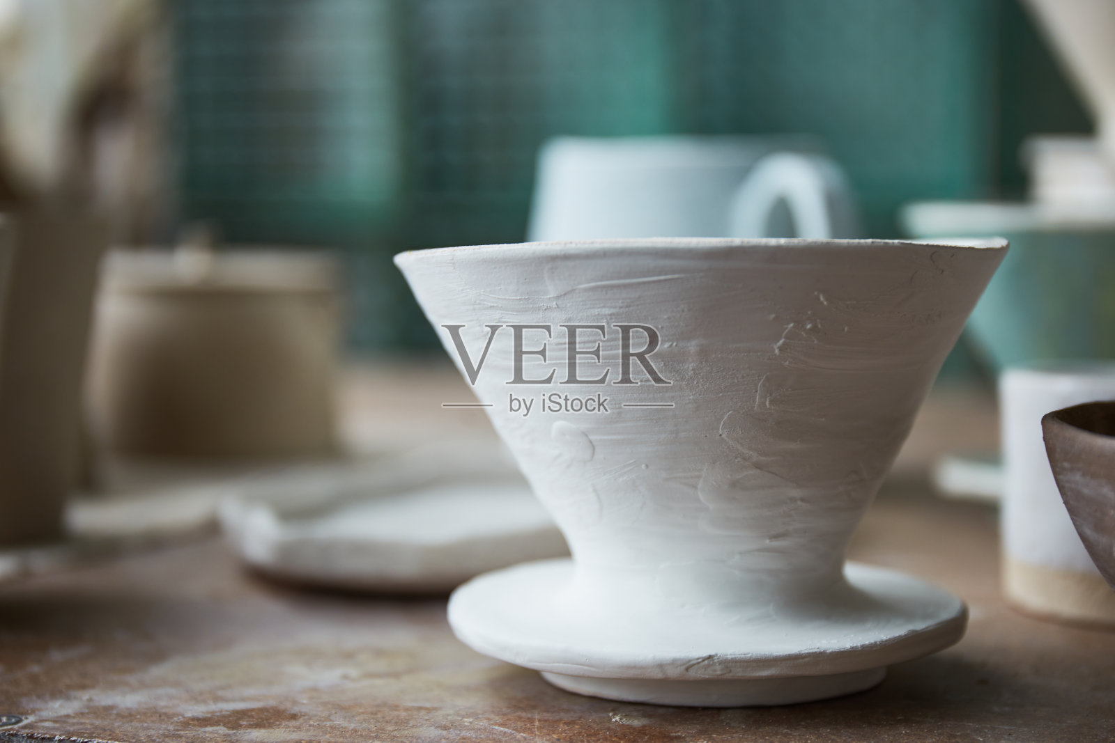 陶瓷师的工作台。粘土车间。制作陶器的过程。这位陶瓷大师在她的工作室里工作照片摄影图片