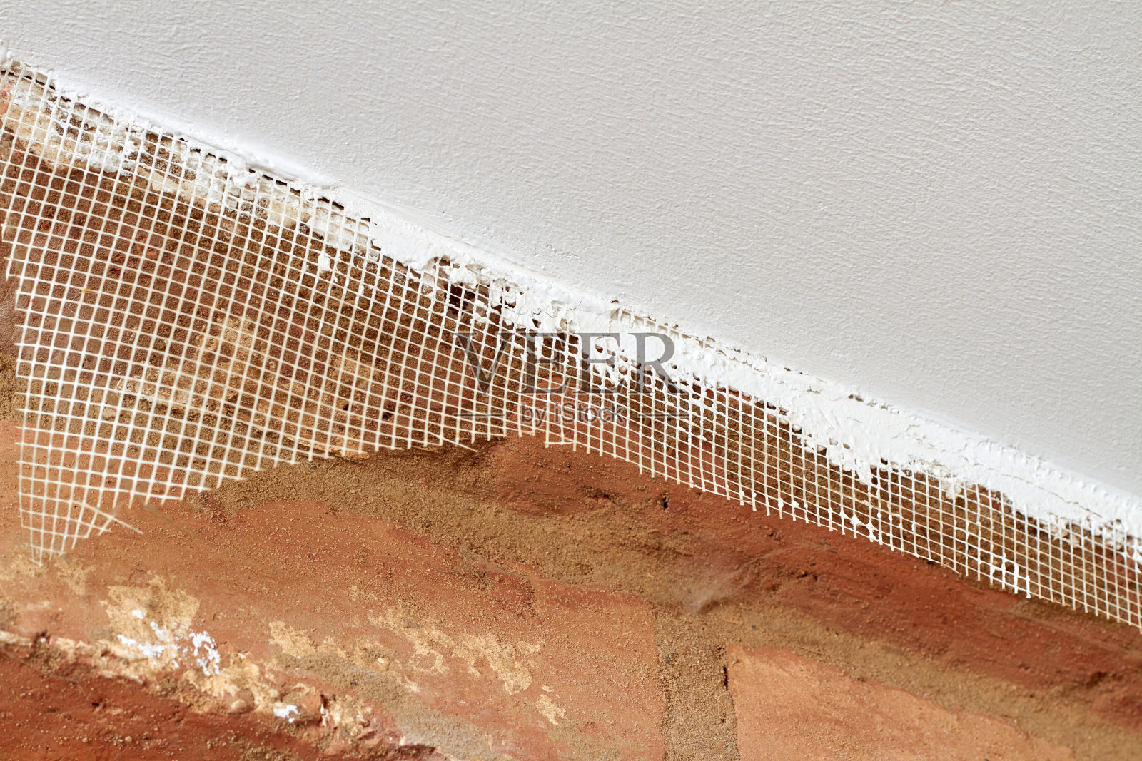 房屋天花板翻新,胶泥层保温层,钢筋网,饰面渲染,灰泥。建设完成的作品。水泥石膏天花板与网格纹理的特写。照片摄影图片