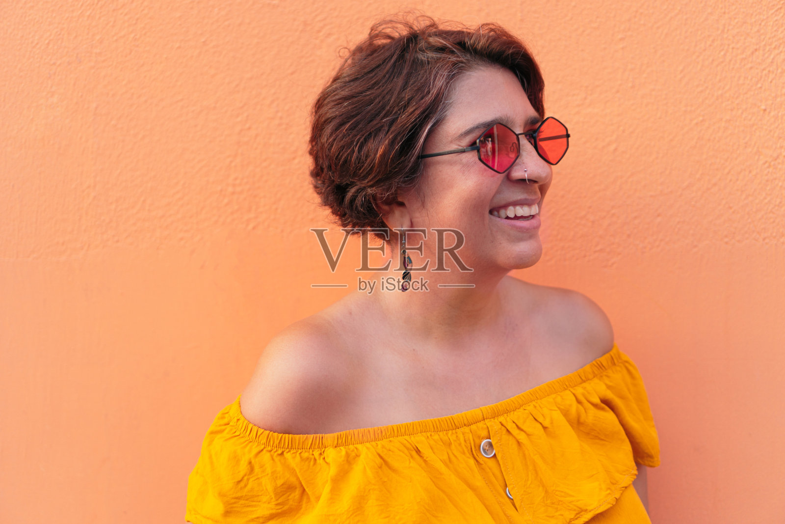 穿着黄色衬衫戴着墨镜的成熟女人照片摄影图片