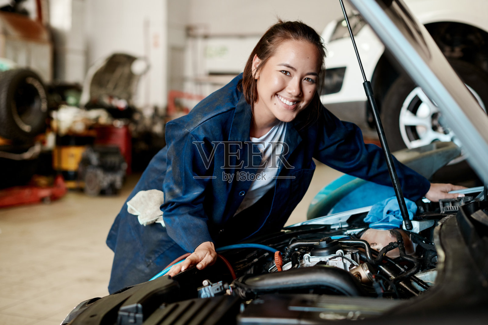 图为一名女机械师在汽车修理店修车照片摄影图片