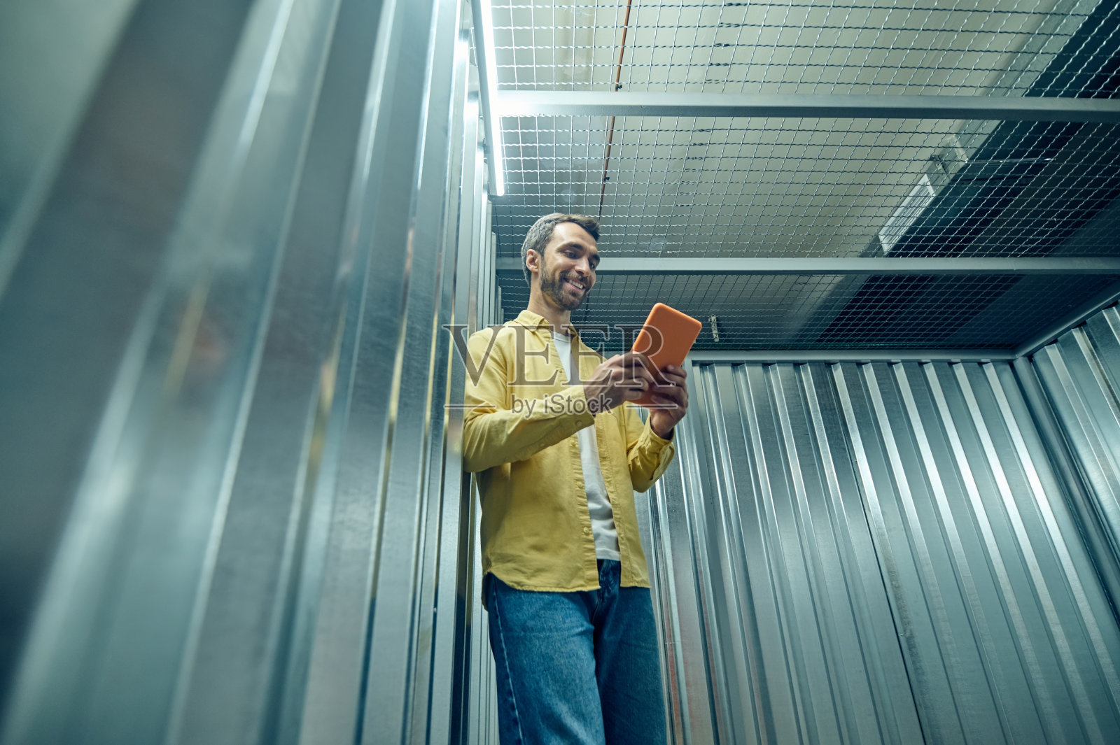 乐观的年轻人在车库里看着平板电脑照片摄影图片