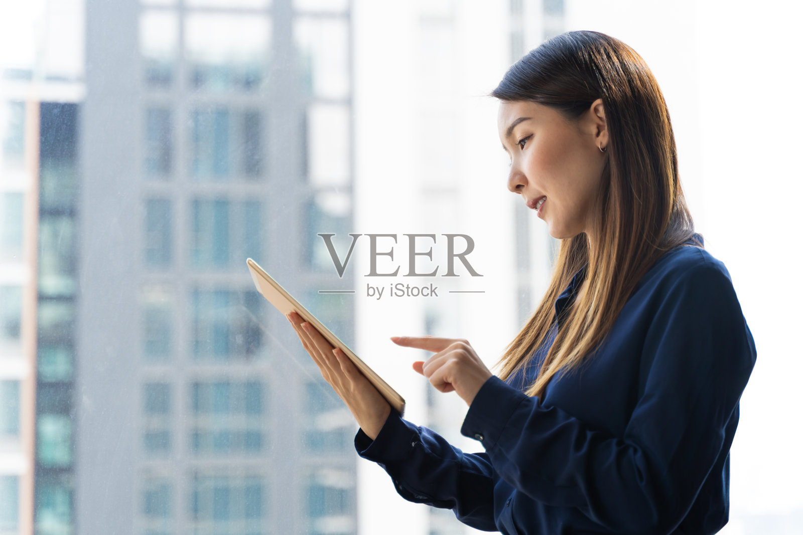 亚洲女商人在出差时在酒店房间里使用数字平板电脑工作照片摄影图片