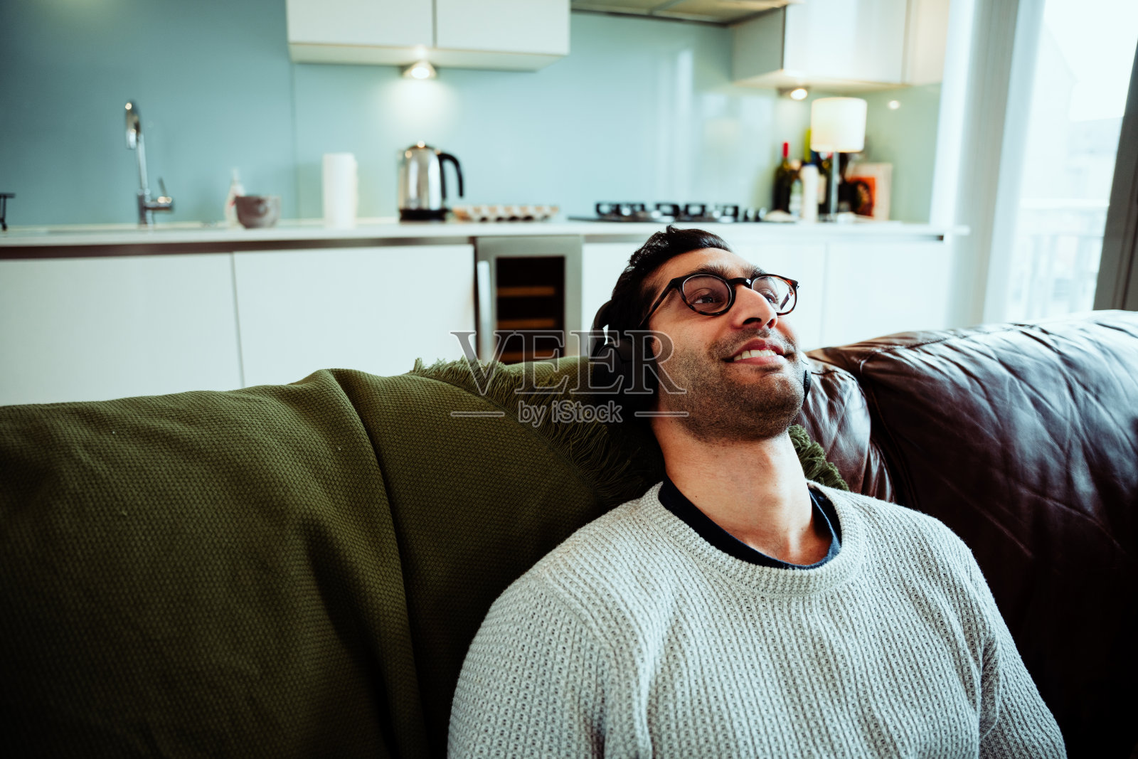 快乐的混合种族男性享受休息时间听音乐戴着耳机照片摄影图片