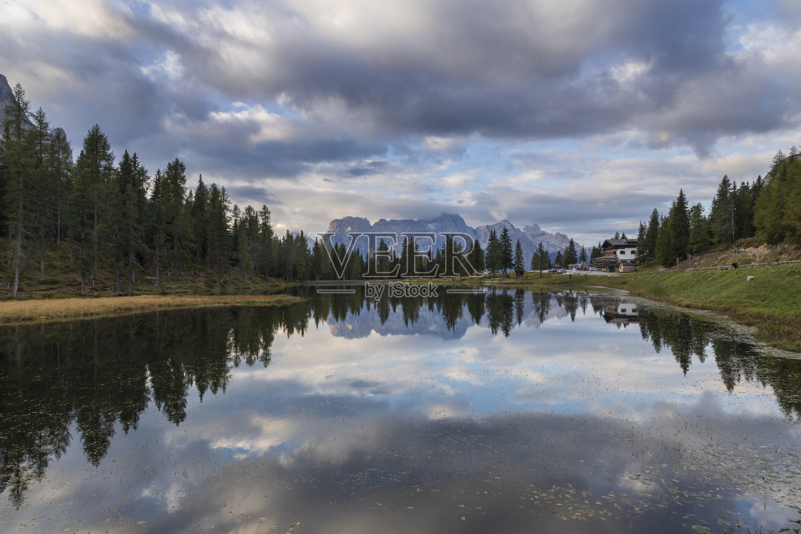 意大利多洛米特山脉中的Antorno湖,水中倒影着山脉。天空中有美丽的云。你可以看到去特里奇梅的路照片摄影图片