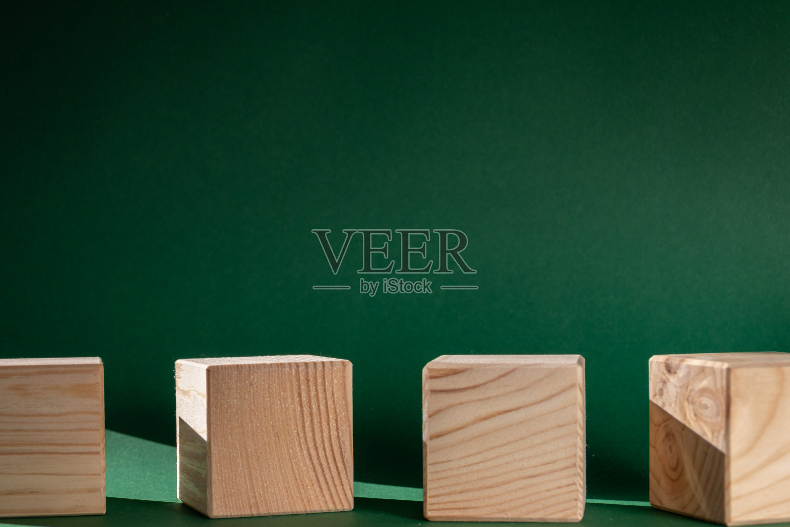 木制的立方体在翠绿色的背景下依然栩栩如生照片摄影图片