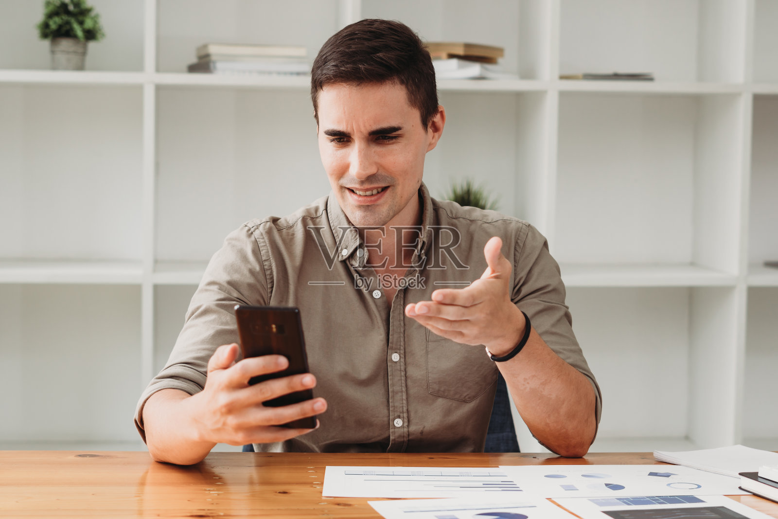 微笑的白人商人工作,用智能手机聊天照片摄影图片
