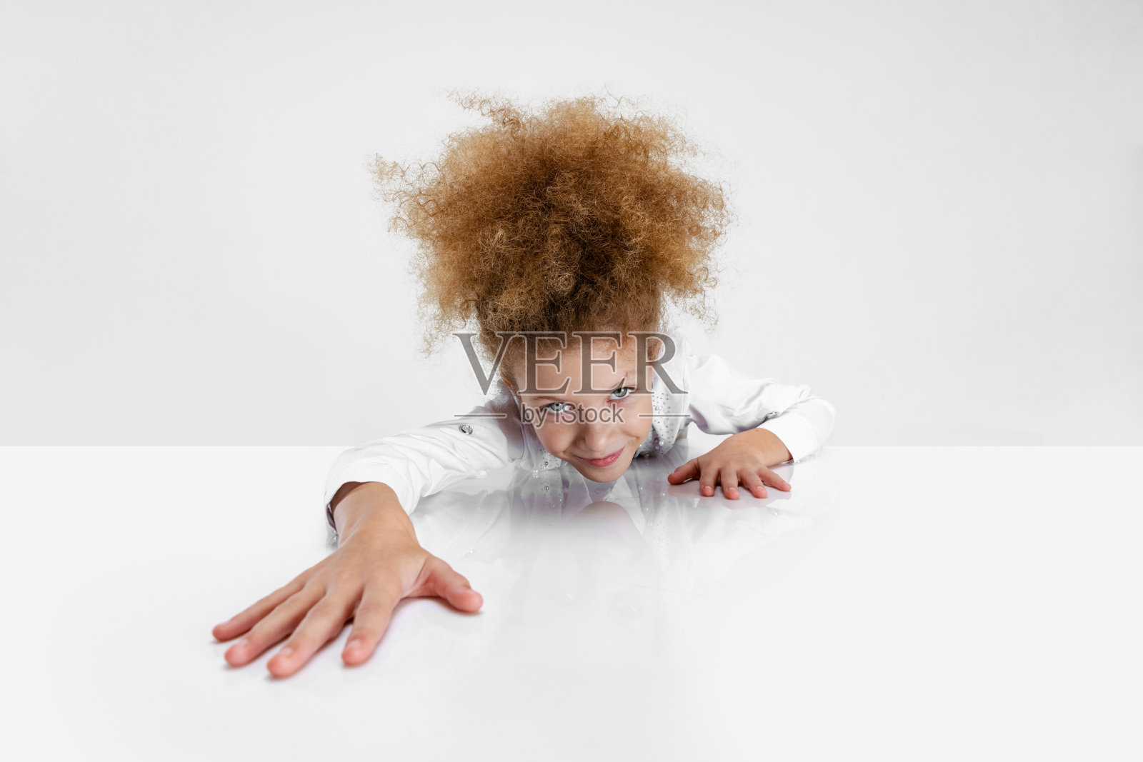 特写肖像美丽的学校女孩坐在和看着相机孤立在白色的背景。照片摄影图片