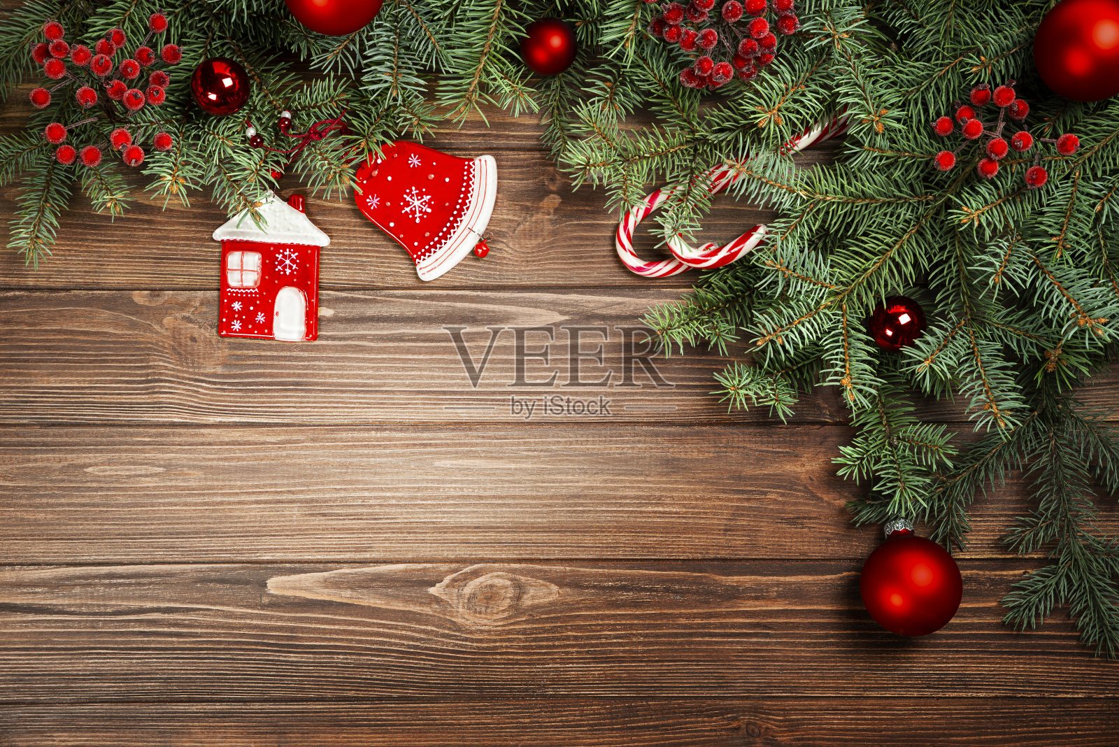 在乡村背景下,由冷杉树枝、玻璃房子、钟、球和花楸组成的Kritsmas框架。照片摄影图片