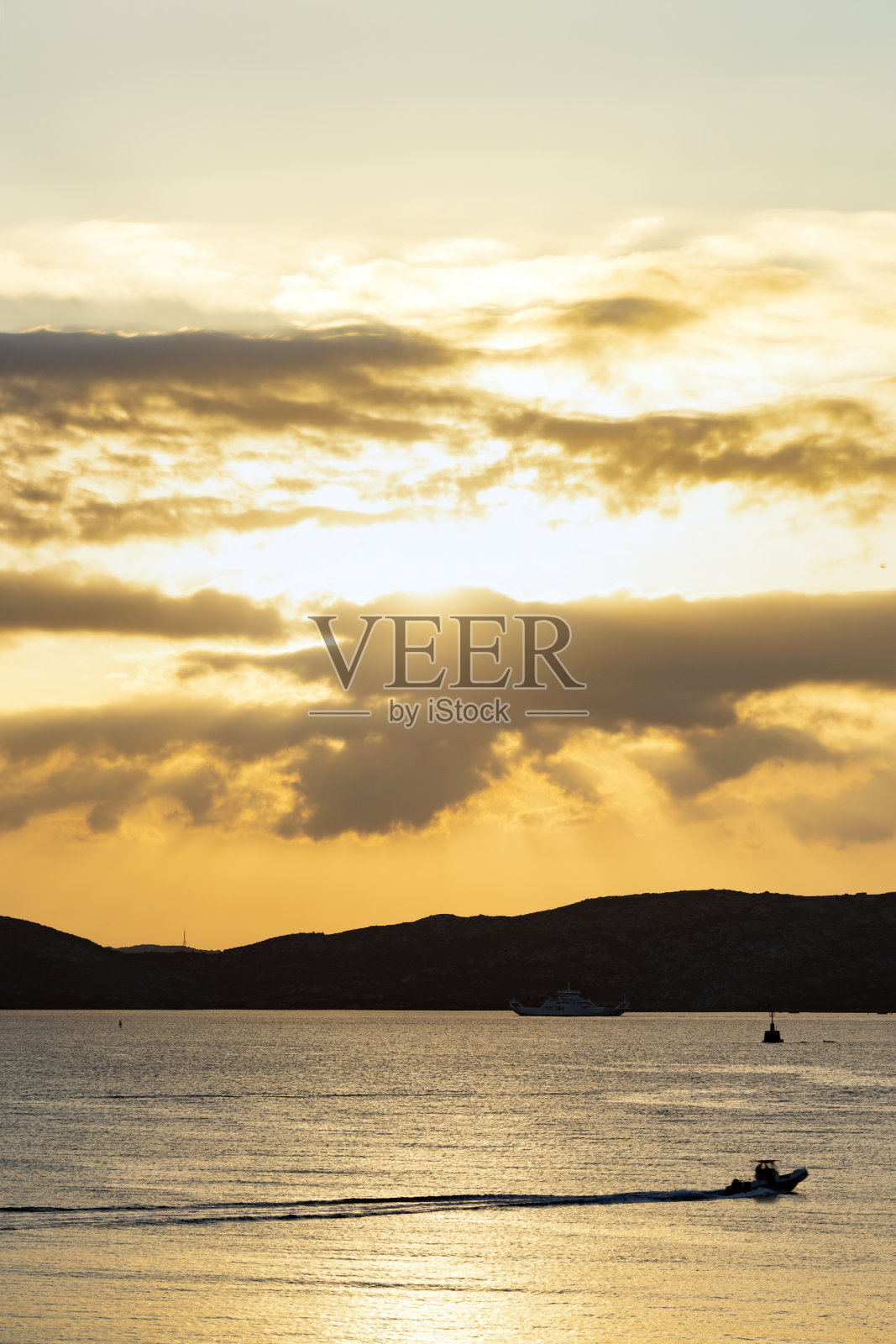 美丽的日出在海岸线的剪影沐浴在平静的大海。意大利,撒丁岛,多云,引人注目的天空。照片摄影图片