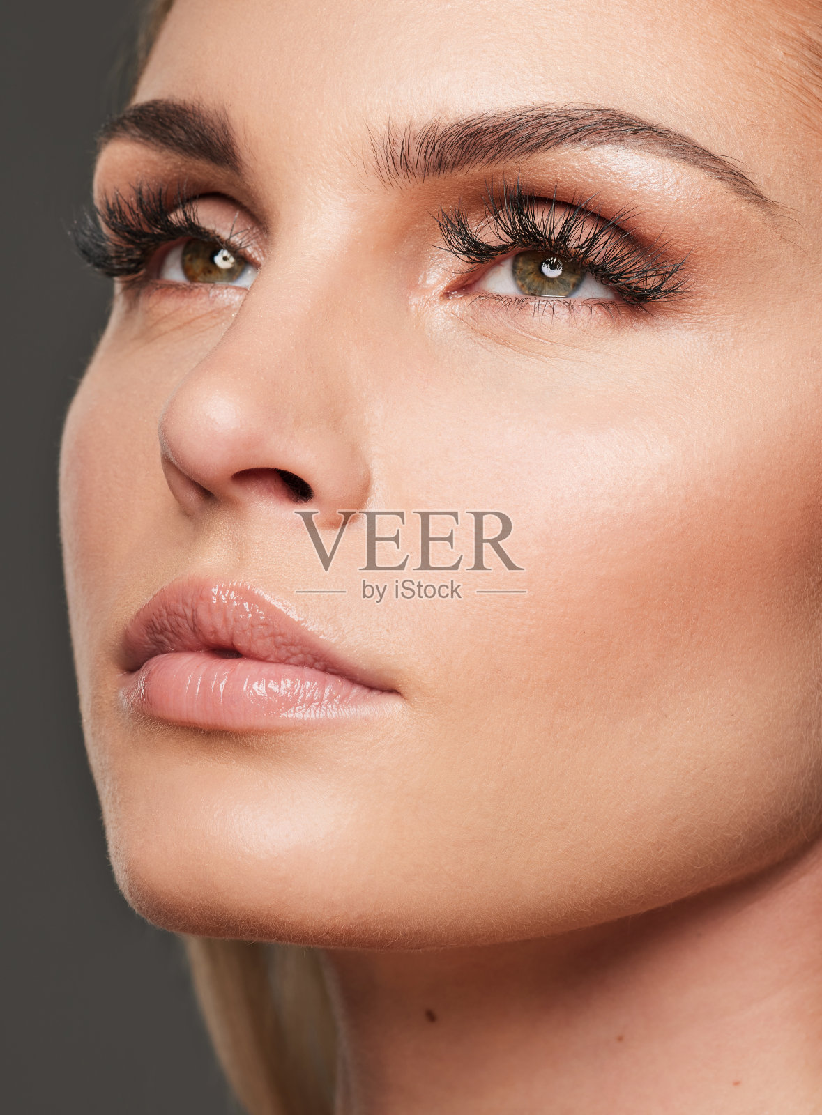 摄影室拍摄的一个美丽的年轻女子站在灰色的背景照片摄影图片