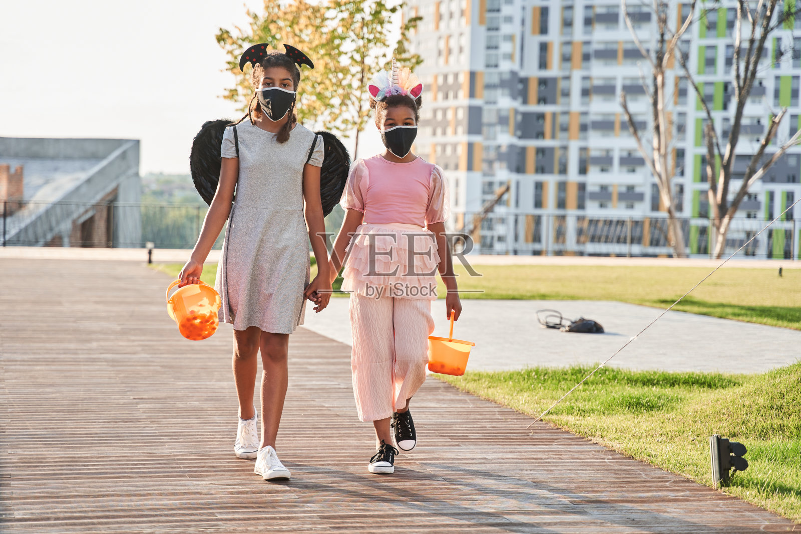 女孩们在万圣节带着水桶散步照片摄影图片