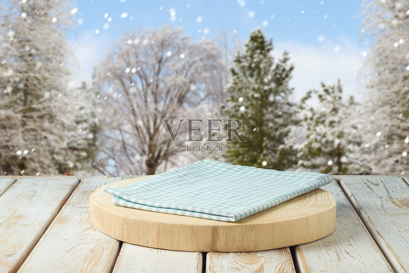 空的原木和桌布上的质朴的桌子在冬季景观背景。圣诞节和新年的模型设计和产品展示。照片摄影图片