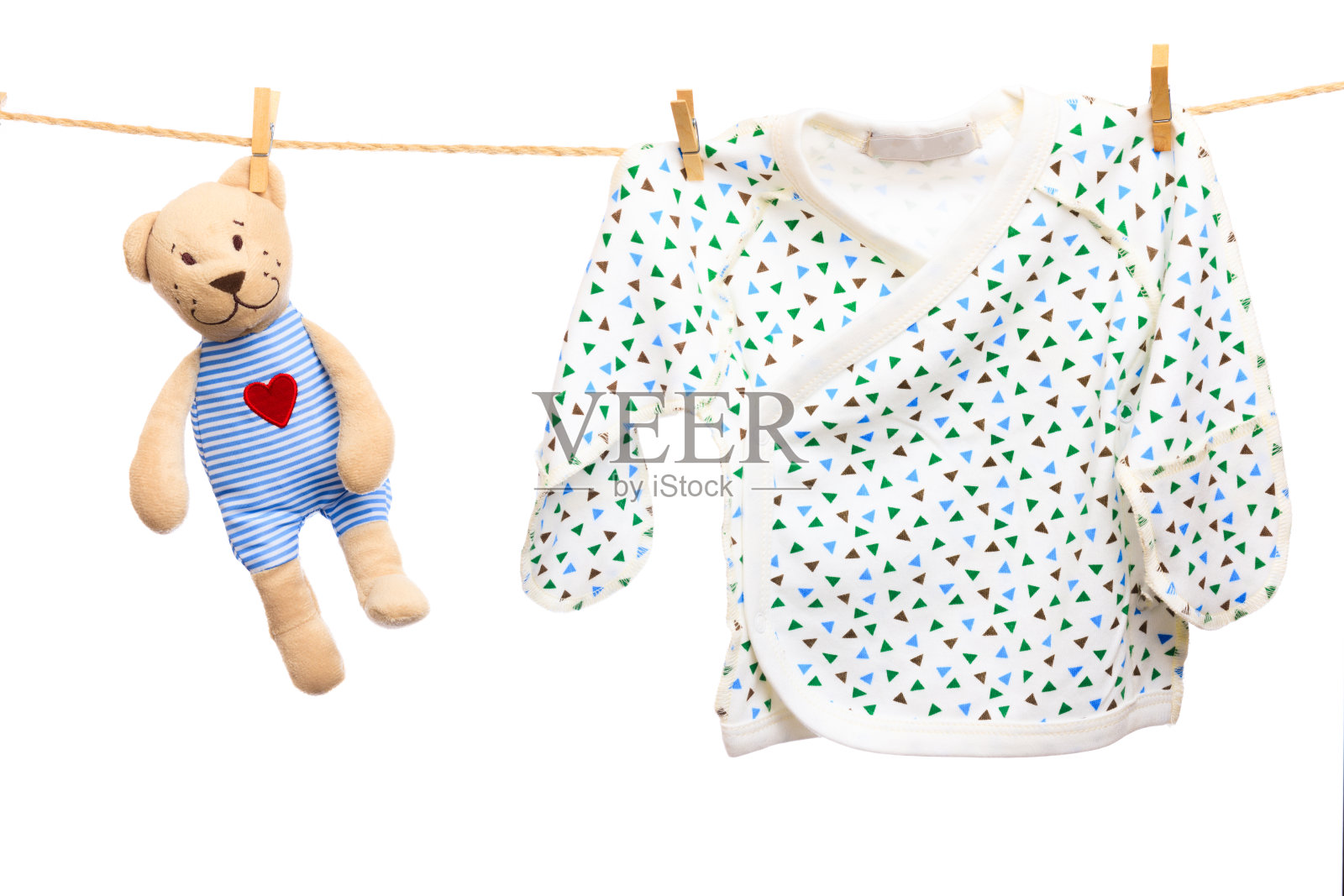 白色背景上晾衣绳上的婴儿衣服和泰迪熊-图片照片摄影图片