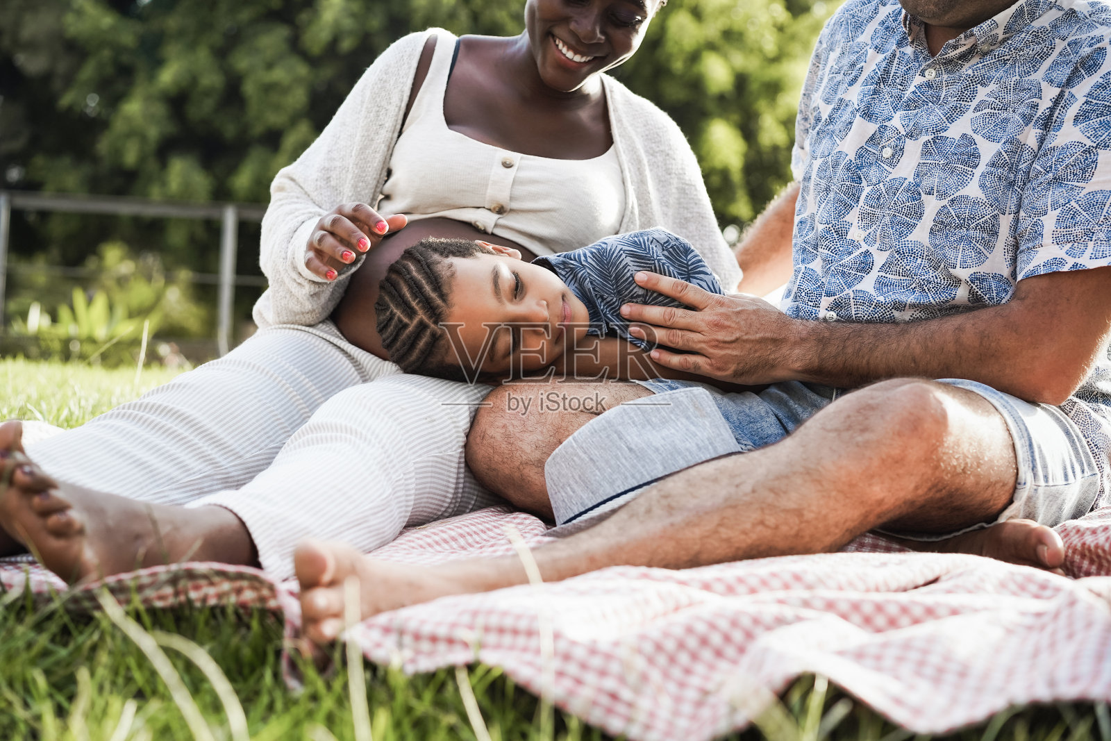多种族家庭在城市公园野餐的温情时刻-关注男孩的脸照片摄影图片