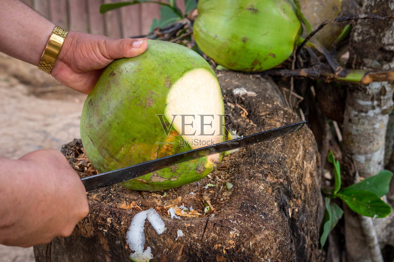 男人用大砍刀开椰子照片摄影图片