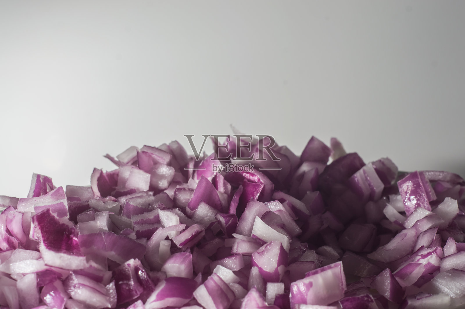 红洋葱切成小块,白色背景照片摄影图片