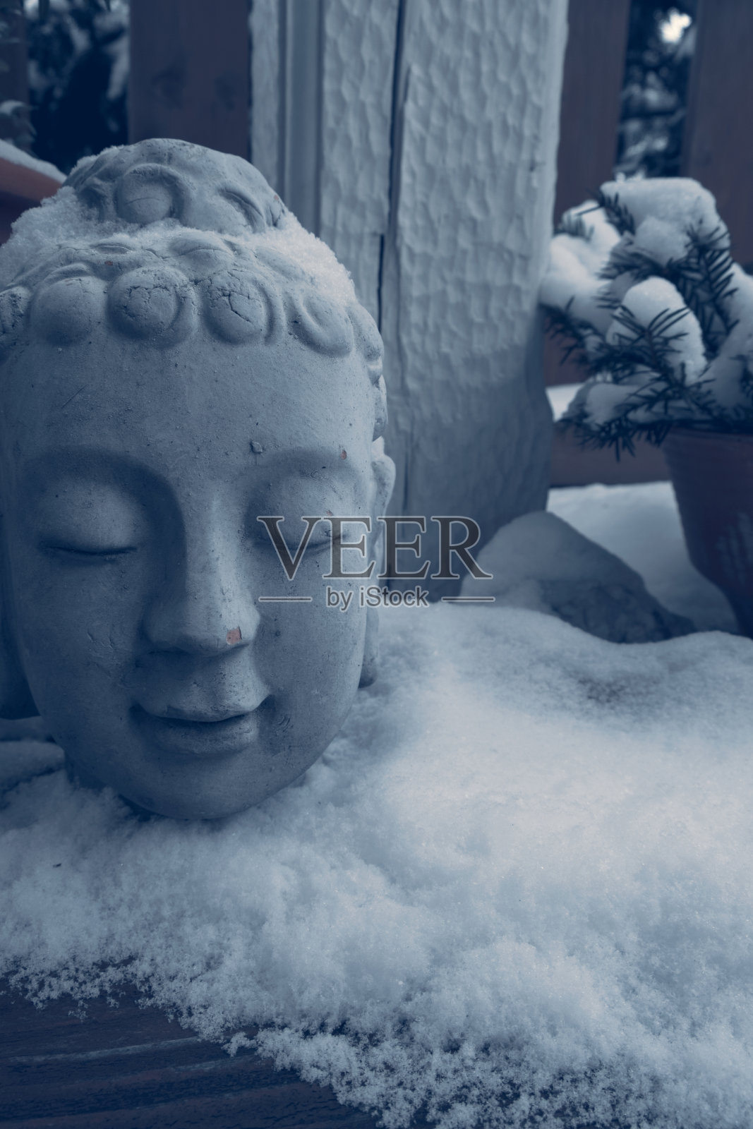 木台上的石佛头被雪覆盖照片摄影图片