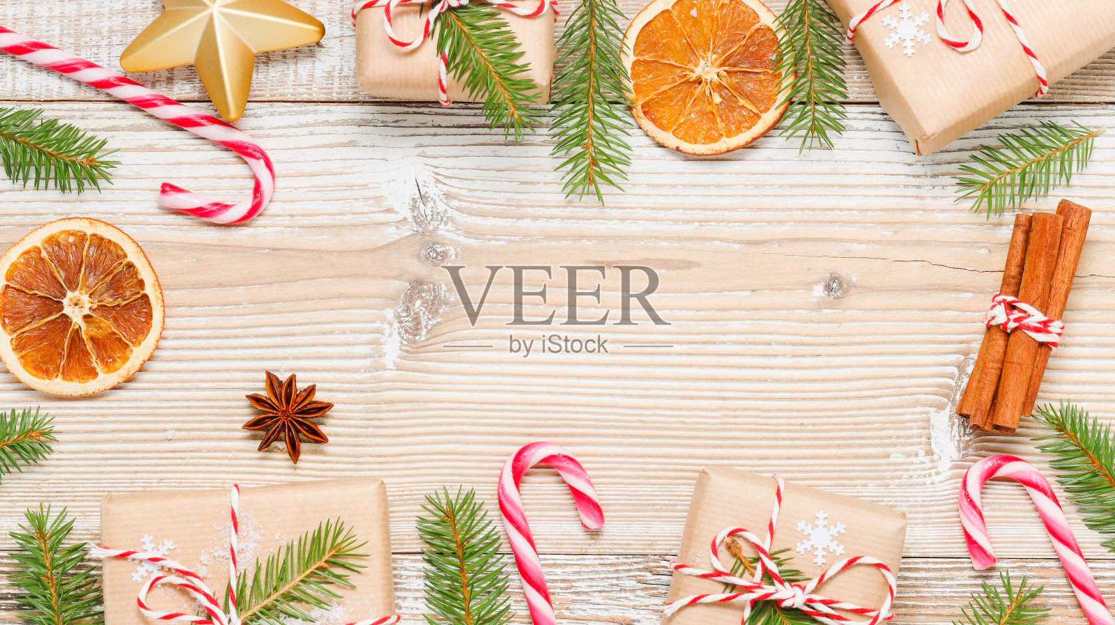 圣诞框架与礼品盒和糖果手杖,枞树,干桔子和冬季装饰照片摄影图片