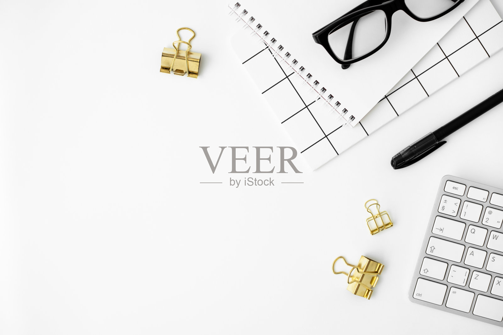 教育的概念。键盘、笔记本、黑色眼镜、钢笔和白色背景上的金色活页夹回形针。回到学校平躺。时尚的办公空间。文具用品。复制空间,俯视图照片摄影图片