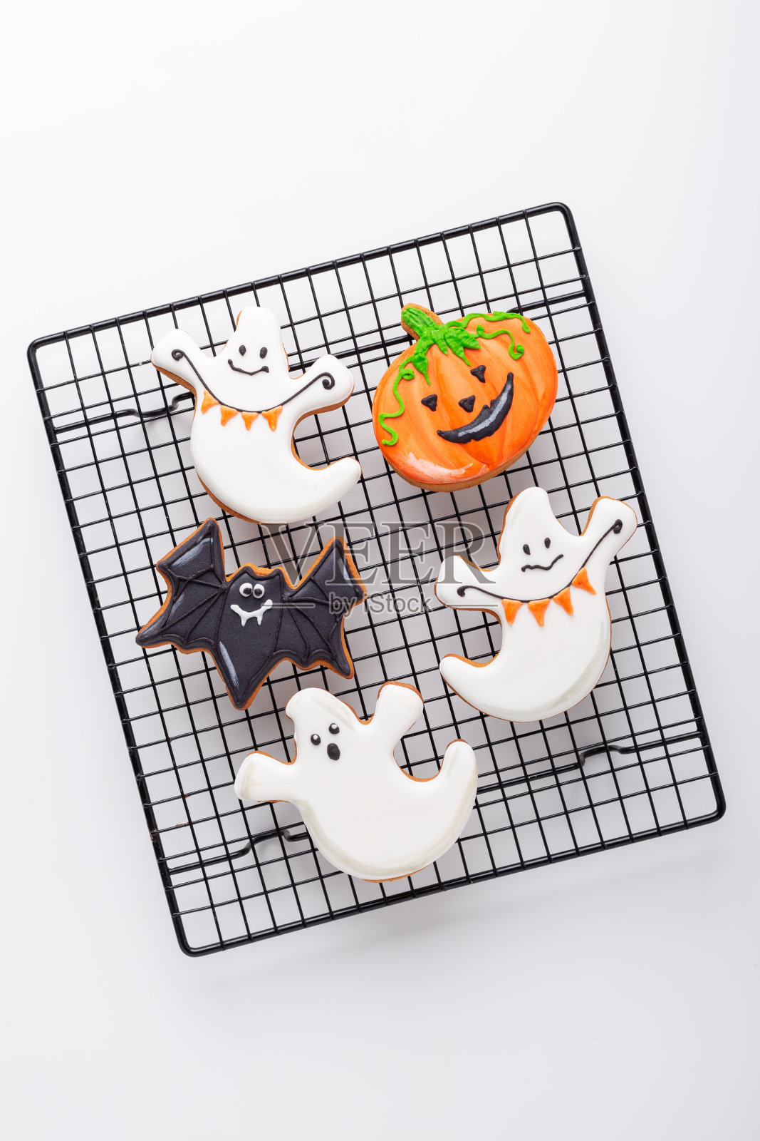 万圣节姜饼曲奇饼在烤架上的白色背景。明亮的自制饼干万圣节派对照片摄影图片