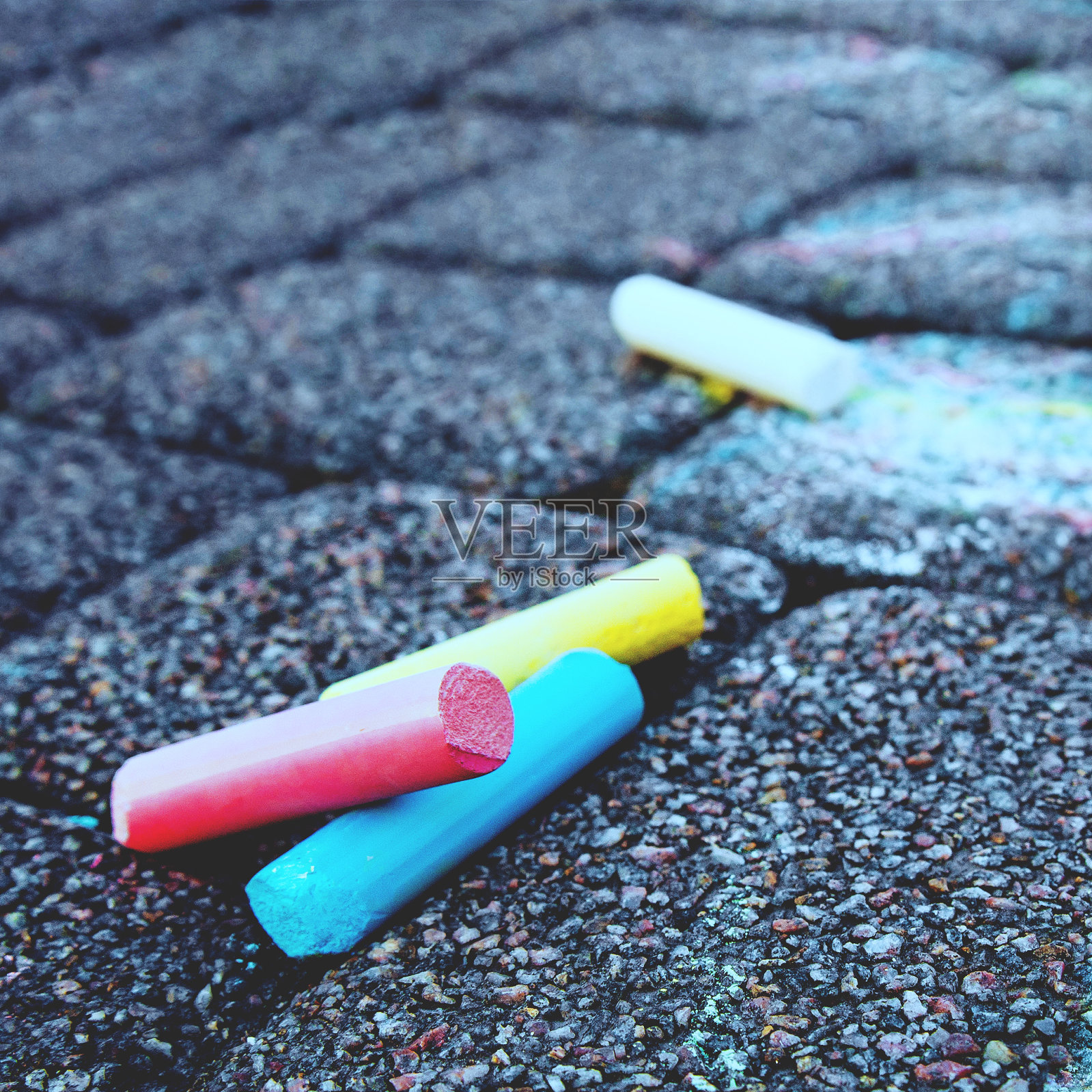 模糊图像彩色蜡笔人行道粉笔在黑暗的沥青背景。照片摄影图片