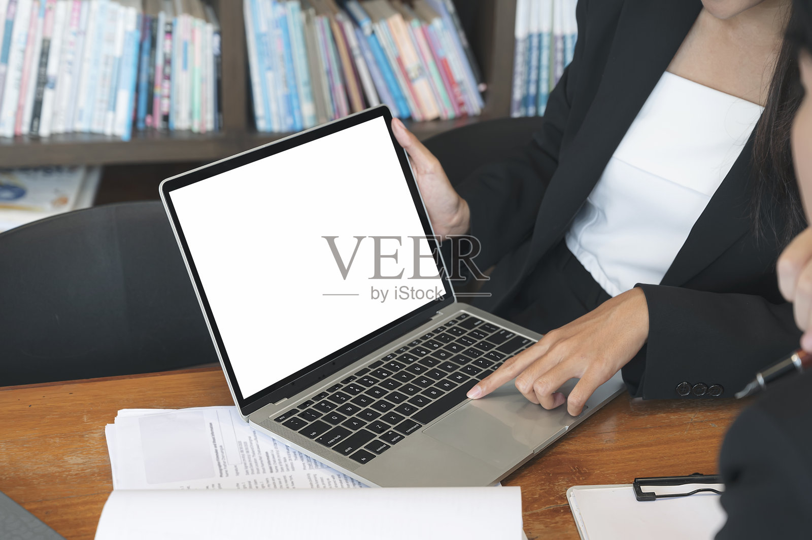 商务人士手握笔记本电脑,讨论商业计划。照片摄影图片