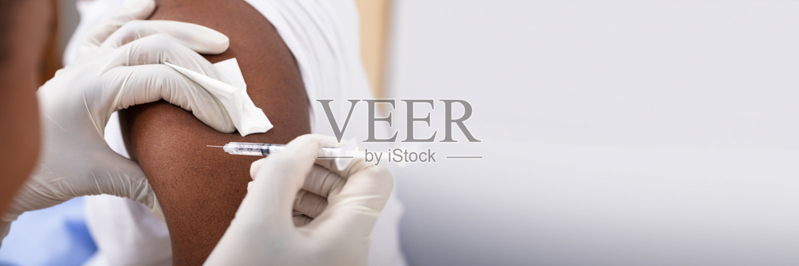 医生给病人的手臂注射注射器照片摄影图片