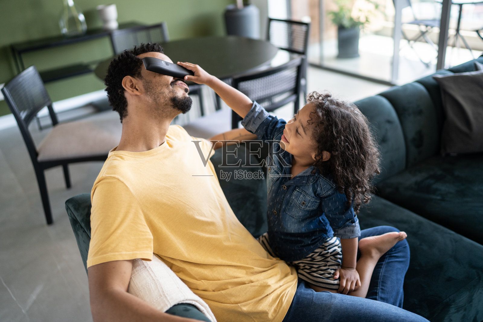 父亲和儿子在家里玩遥控器照片摄影图片