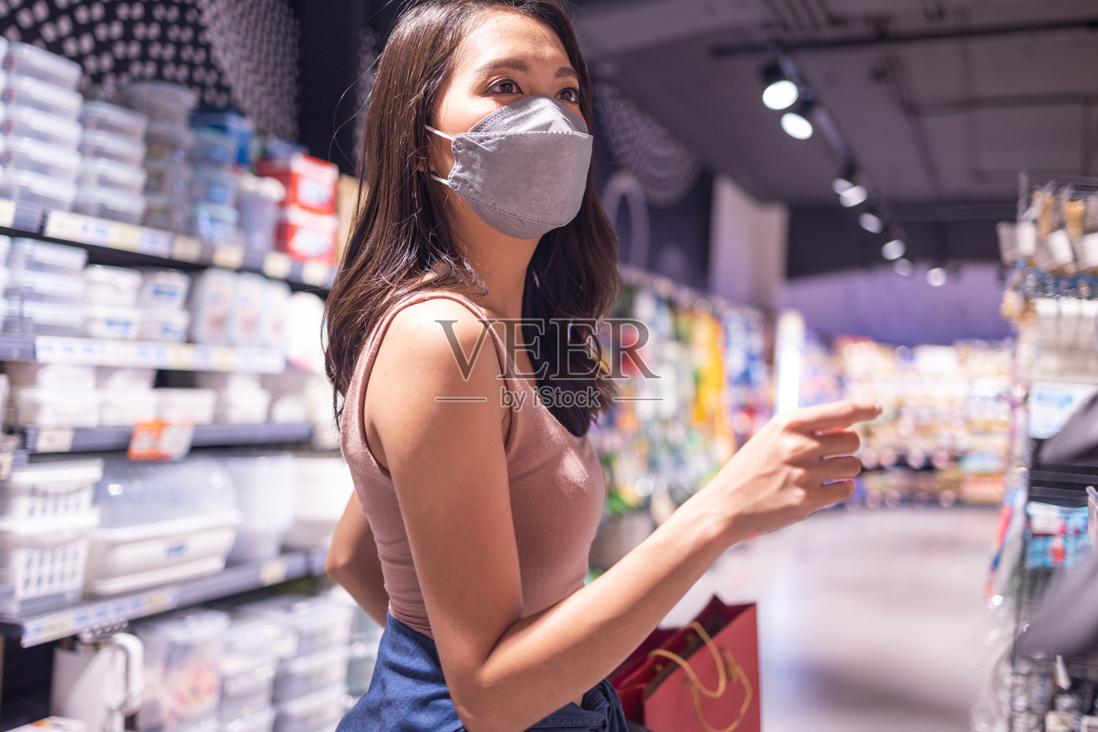 新常态购物,亚洲女性购物在服装商店与面膜。照片摄影图片