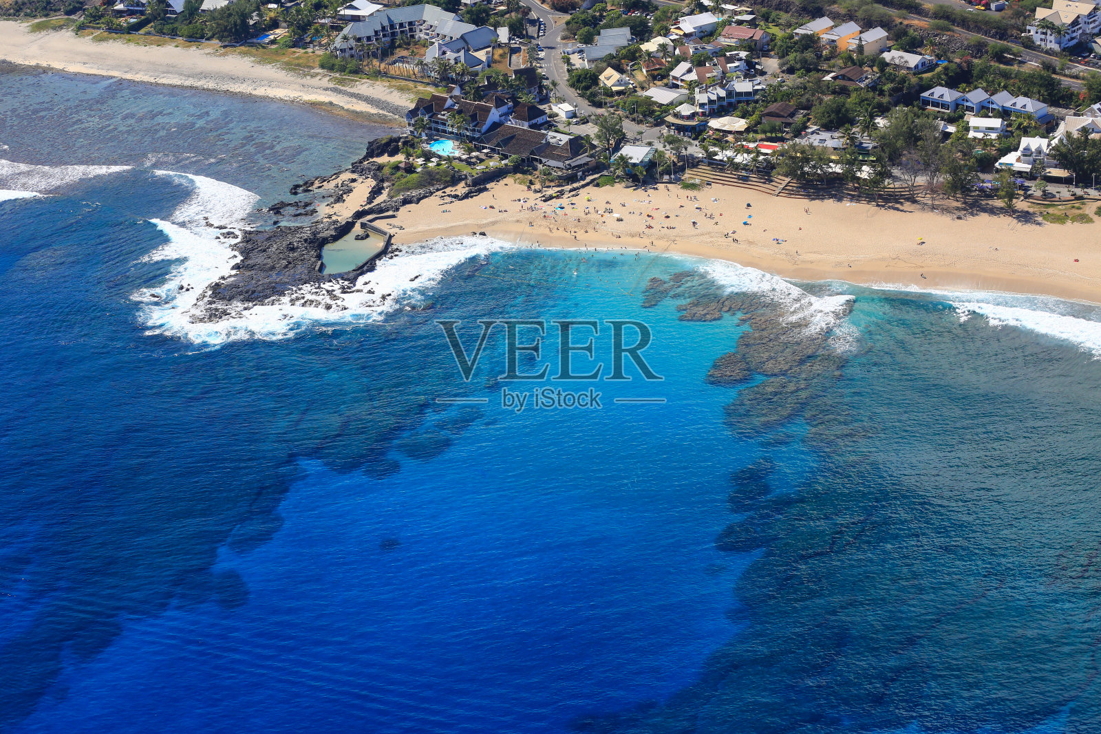 西留尼汪岛清澈的蓝色泻湖水域,白色的沙滩和圣吉勒斯市照片摄影图片