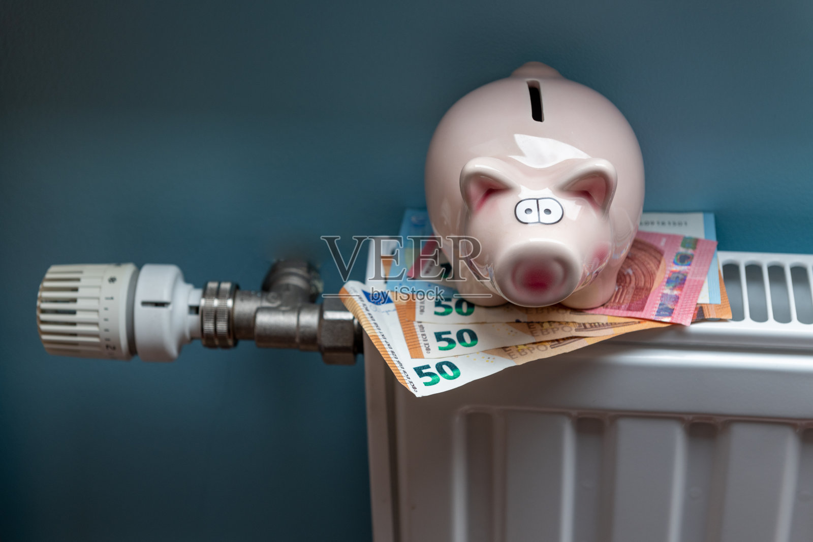 存钱罐和散热器上的钱。冬季节约采暖照片摄影图片