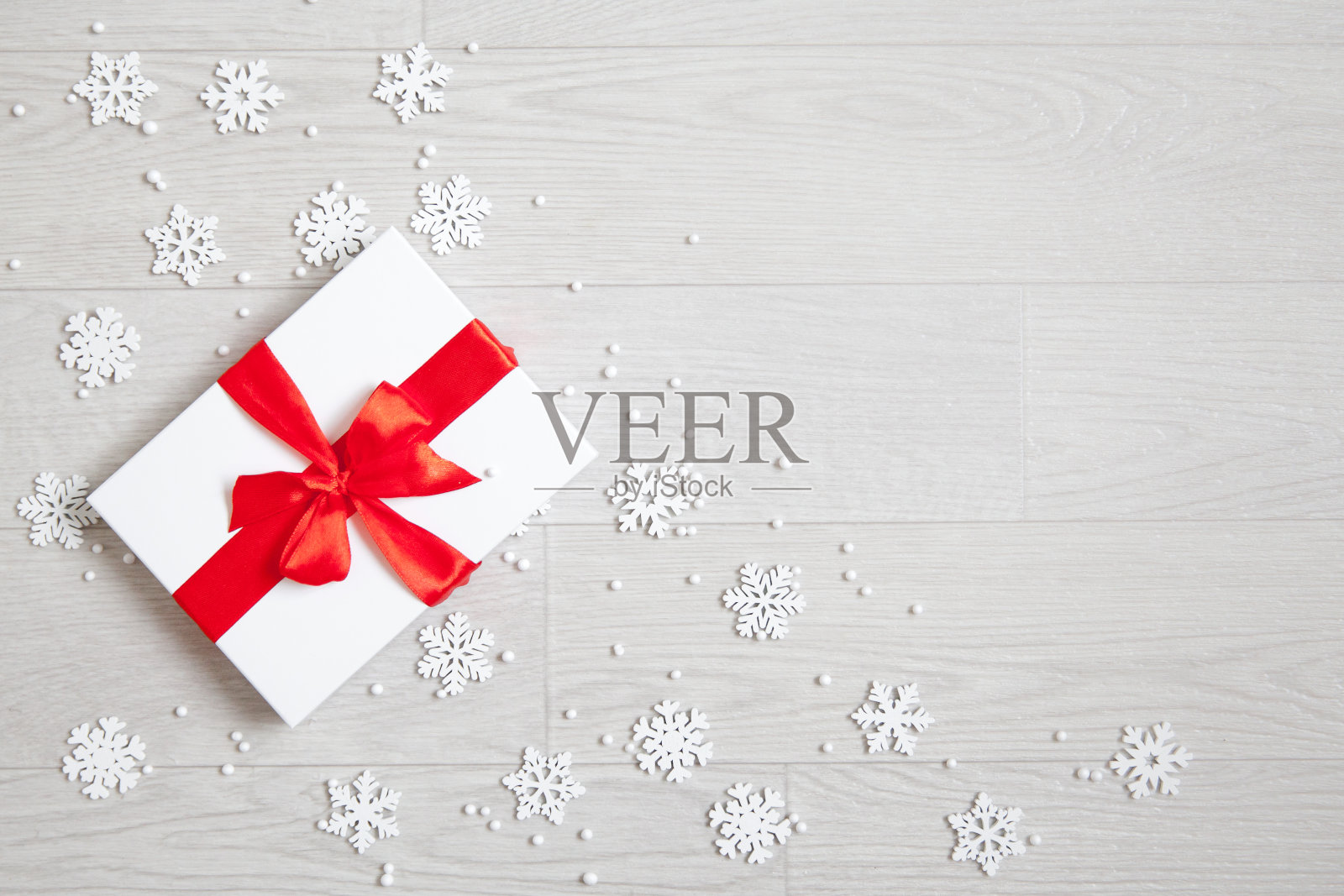 礼物上有红色的蝴蝶结和雪花。新年礼物。照片摄影图片