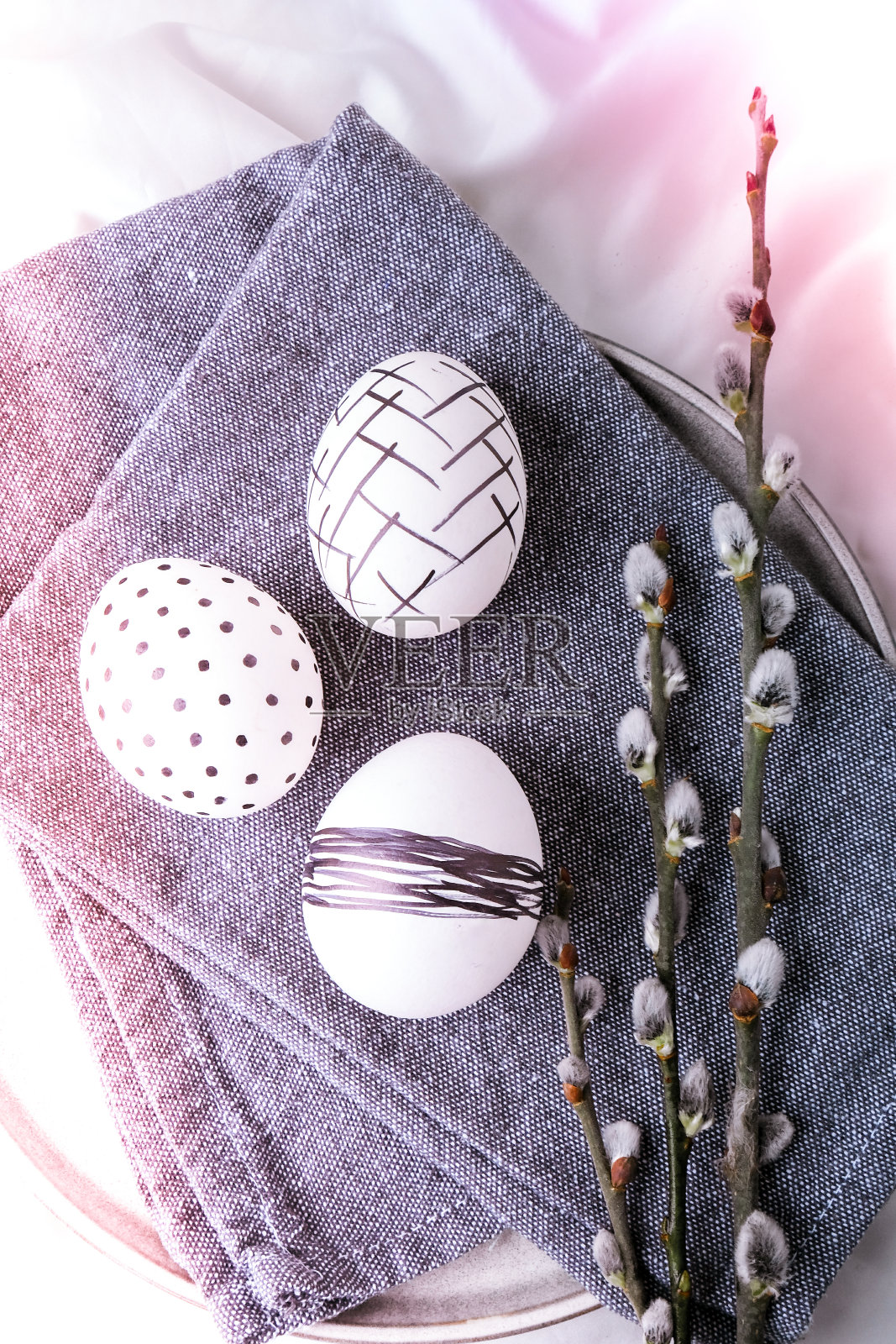 时尚的彩色时尚的天然复活节彩蛋,羽毛,猫咪柳树枝上的乡村布上的白色丝绸织物。平的。复活节的静物照片摄影图片