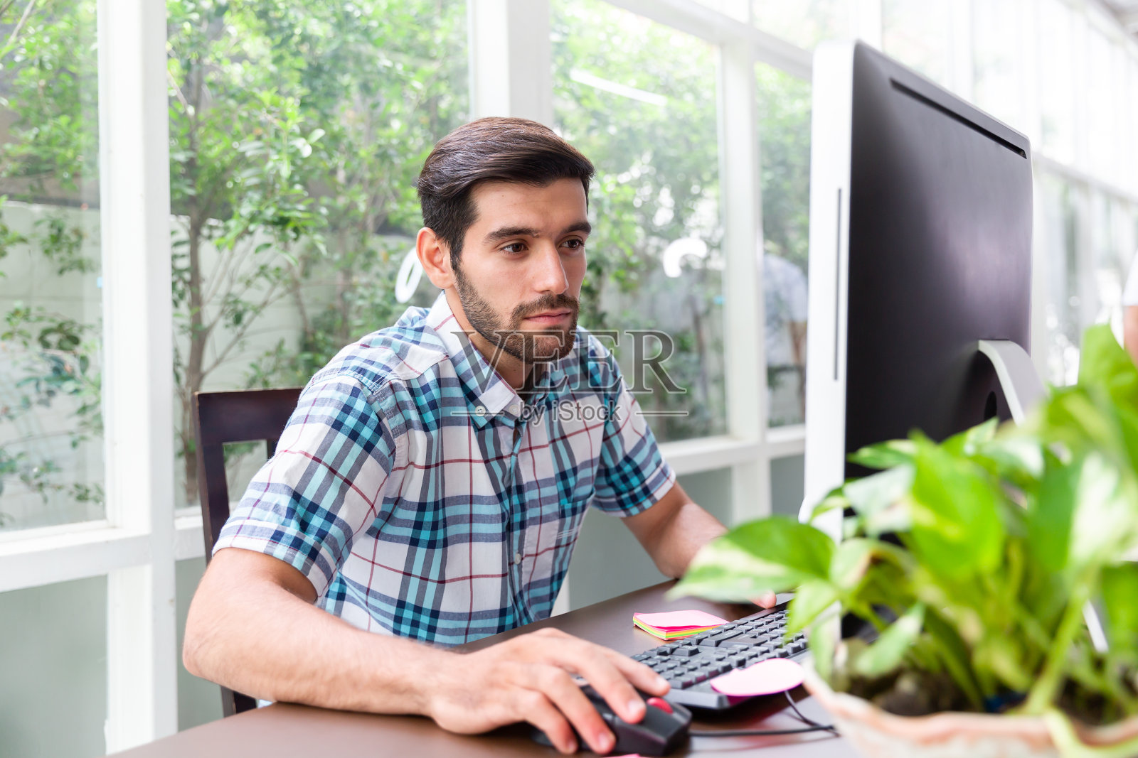 创意男人在家办公,桌上放着电脑桌面、文件纸和一杯咖啡。商人在家工作,通过社交网络交流。照片摄影图片